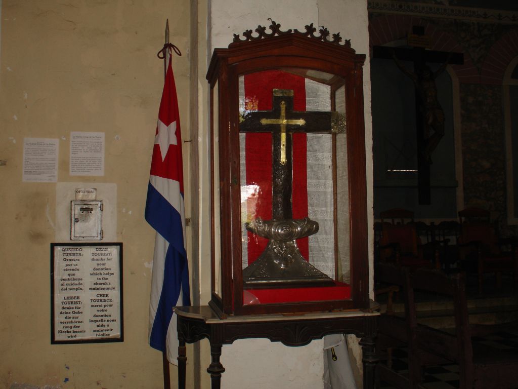 Dieses Kreuz soll Kolumbus angeblich aus Spanien mitgebracht und in den kubanischen Strand gesteckt haben. Das Holz des Kreuzes ist etwa 500 Jahre alt, so dass es aus der Zeit von Kolumbus stammt. Allerdings stammt das Holz von einem einheimischen Baum.<br />Nachdem das Kreuz dadurch, dass Wallfahrer sich Splitter mitgenommen hatten, von zwei auf einen Meter geschrumpft war, wurde es in einen Glaskasten gestellt.