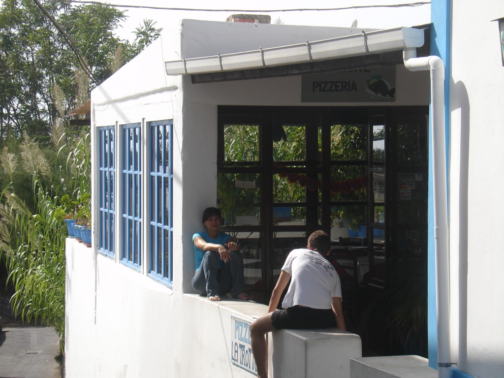 Bedienungen ruhen sich am Nachmittag vor einer Pizzeria aus.